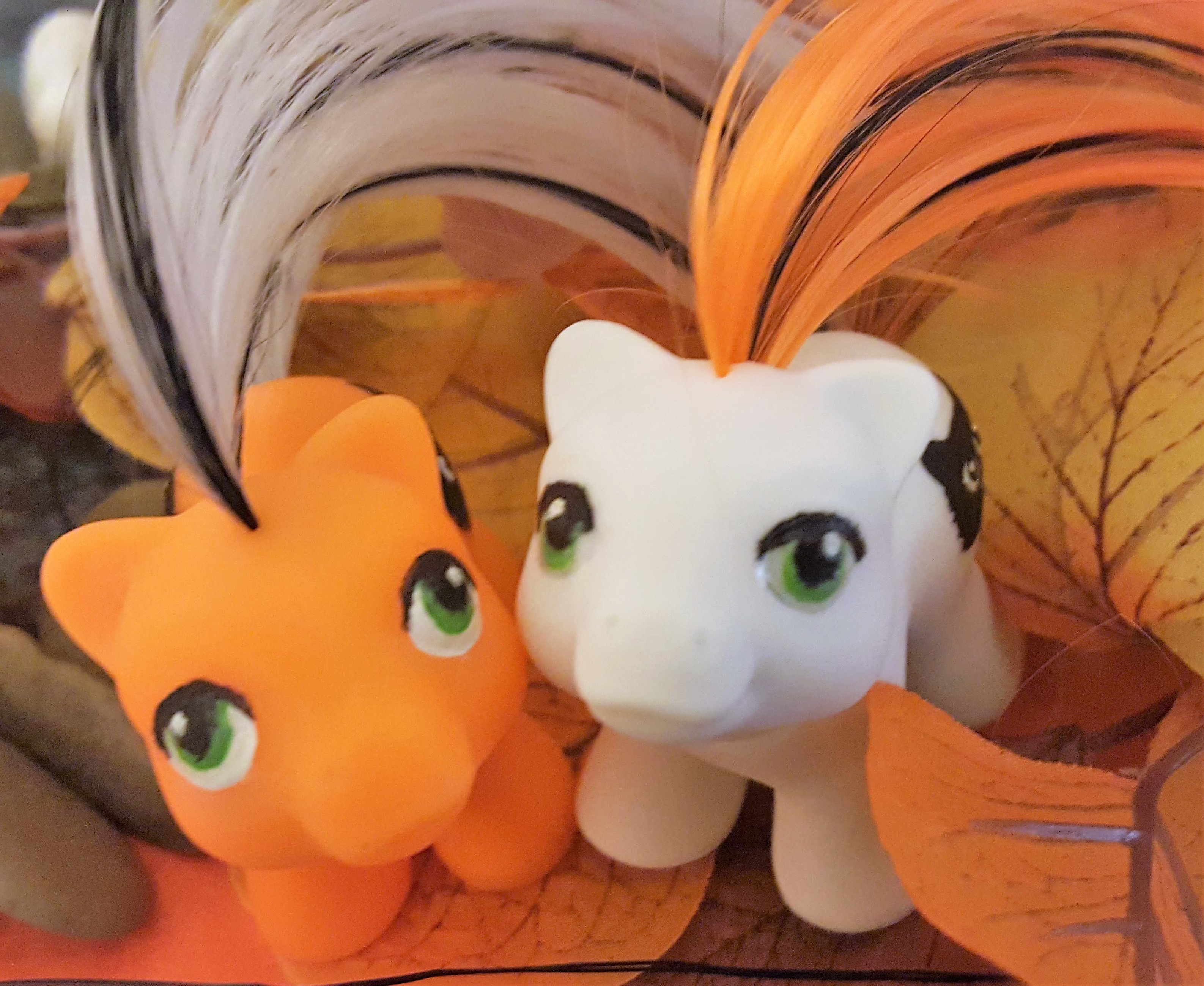 Halloween themed newborn baby ponies in orange and white with green eyes